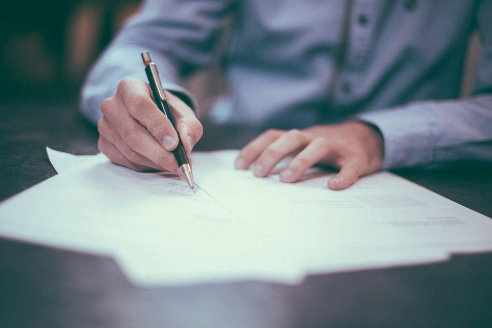 Hands reviewing contracts and financial documents at a desk